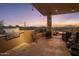 Covered outdoor grilling area next to an outdoor dining area and desert sunset views at 38951 N 101St Way, Scottsdale, AZ 85262