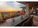 Outdoor patio features desert sunset views, a stone pillar structure, and an outdoor dining set at 38951 N 101St Way, Scottsdale, AZ 85262