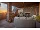 Covered patio has a stone fireplace, comfortable seating, and scenic desert views at sunset at 38951 N 101St Way, Scottsdale, AZ 85262