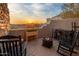Outdoor patio with rocking chairs, a fire pit, and sunset desert views in a tranquil setting at 38951 N 101St Way, Scottsdale, AZ 85262