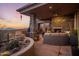 Outdoor living space with a stone fireplace, comfortable seating, and lush desert landscaping, perfect for relaxation at 38951 N 101St Way, Scottsdale, AZ 85262