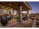 Inviting covered patio featuring stone columns, comfortable seating, and an outdoor dining area with desert views at 38951 N 101St Way, Scottsdale, AZ 85262