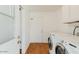 Bright laundry room featuring modern appliances, storage cabinets, and a doorway at 4226 E Diamond Ave, Mesa, AZ 85206