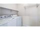Bright laundry room features a white washer and dryer, tiled flooring, and white shelving at 5450 E Mclellan Rd # 133, Mesa, AZ 85205