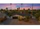 Sunset aerial view of a house with desert landscaping, palm trees, and a two car garage at 5916 E Hearn Rd, Scottsdale, AZ 85254