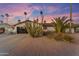 A charming home with desert landscaping featuring a two car garage, palm trees, and comfortable seating at 5916 E Hearn Rd, Scottsdale, AZ 85254