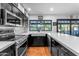 Well-lit kitchen featuring stainless appliances, white countertops, and black cabinetry at 5916 E Hearn Rd, Scottsdale, AZ 85254