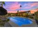 Inviting pool is surrounded by lush landscaping and patio furniture under a beautiful sky at 5916 E Hearn Rd, Scottsdale, AZ 85254