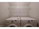 Functional laundry room featuring modern washer and dryer with shelving for storage at 6760 S Russet Sky Way, Gold Canyon, AZ 85118