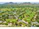 Aerial view of golf course community with ponds, lush green fairways, and mountain views at 7155 E Oakmont Dr, Paradise Valley, AZ 85253