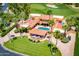 Expansive estate with terracotta roofs, a pool, and a landscaped yard bordering a verdant golf course at 7155 E Oakmont Dr, Paradise Valley, AZ 85253