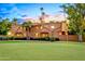 Beautiful home showcasing manicured grounds with lush greenery and a golf course view at 7155 E Oakmont Dr, Paradise Valley, AZ 85253
