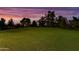 Expansive green golf course landscape under a stunning sunset sky with scattered trees at 7155 E Oakmont Dr, Paradise Valley, AZ 85253