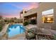 Outdoor patio with stylish wicker furniture, beautiful pool, and attractive desert plants, perfect for entertaining at 11082 E Mark Ln, Scottsdale, AZ 85262