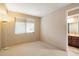 Bright bedroom with beige carpet has an attached bath and lots of space at 11082 E Mark Ln, Scottsdale, AZ 85262