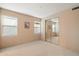 Cozy carpeted bedroom features a mirrored closet and bright natural light from the windows at 11082 E Mark Ln, Scottsdale, AZ 85262