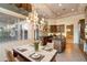 Dining area with elegant chandelier, marble table and kitchen view at 11082 E Mark Ln, Scottsdale, AZ 85262