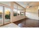 Bright living area with hardwood floors, a ceiling fan, access to the back patio, and transom windows at 11082 E Mark Ln, Scottsdale, AZ 85262