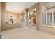 Bright living room with neutral walls, white carpet, shuttered windows, and an arched entryway with elevated ceilings at 11082 E Mark Ln, Scottsdale, AZ 85262