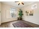Bright living room features hardwood floors, area rug, large windows, ceiling fan, and decorative art at 11082 E Mark Ln, Scottsdale, AZ 85262