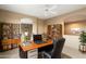 Well-lit office space featuring custom bookshelves, a ceiling fan, and a large desk at 11082 E Mark Ln, Scottsdale, AZ 85262