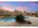 Backyard pool showcasing tiled accents, lush desert plants, stone surround, and sunset ambiance at 11082 E Mark Ln, Scottsdale, AZ 85262