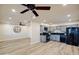 Open-concept kitchen and dining area with grey cabinets, black appliances, and wood-look flooring at 1133 E 4Th St, Casa Grande, AZ 85122