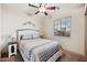 Cozy bedroom with a ceiling fan, a large window, and stylish decor for comfortable living at 11451 E Starkey Ave, Mesa, AZ 85212