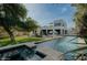 Expansive backyard with a pool, lush lawn, and a stylish white modern home, ideal for outdoor enjoyment and relaxation at 11745 N 99Th St, Scottsdale, AZ 85260
