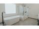 Bright bathroom features modern tub and shower with glass door at 11745 N 99Th St, Scottsdale, AZ 85260