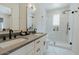 Modern bathroom with double vanity, sleek mirrors, and a glass-enclosed shower at 11745 N 99Th St, Scottsdale, AZ 85260