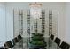 Large dining room table with a glass-enclosed wine cellar as a striking backdrop at 11745 N 99Th St, Scottsdale, AZ 85260