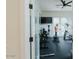Bright exercise room with ceiling fan, wall-mounted tv, and glass doors at 11745 N 99Th St, Scottsdale, AZ 85260