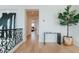 Upstairs hallway with decorative plant, elegant railing, and view to bedroom at 11745 N 99Th St, Scottsdale, AZ 85260