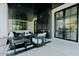 Covered patio boasts modern furniture, sleek fireplace, and seamless indoor-outdoor flow with black-framed glass doors at 11745 N 99Th St, Scottsdale, AZ 85260