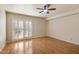 Spacious bedroom with a ceiling fan, shutters on the sliding glass doors, and hardwood floors at 1221 E Palacio Dr, Phoenix, AZ 85014