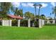 Well-manicured front yard with lush green grass, palm trees, and secure fencing, providing privacy at 1221 E Palacio Dr, Phoenix, AZ 85014