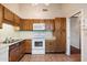 Functional kitchen featuring oak cabinets and white appliances at 1221 E Palacio Dr, Phoenix, AZ 85014