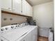 Bright laundry room featuring Whirlpool washer and dryer, upper cabinets, and efficient water heater at 1221 E Palacio Dr, Phoenix, AZ 85014