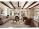 Bright living room featuring exposed beams, fireplace, hardwood floors, and neutral decor at 1221 E Palacio Dr, Phoenix, AZ 85014