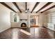 Bright living room with a cozy fireplace, beamed ceilings, and wood floors at 1221 E Palacio Dr, Phoenix, AZ 85014