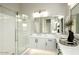 A bathroom with a glass shower, a mirror, a sink, and white cabinets at 12245 E Clinton St, Scottsdale, AZ 85259