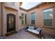 Cozy courtyard featuring a decorative front door, seating area and neutral tones at 12245 E Clinton St, Scottsdale, AZ 85259