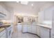 Bright kitchen featuring white cabinetry, tile countertops, and modern appliances at 14817 W Domingo Ln, Sun City West, AZ 85375