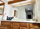 Bathroom vanity featuring spacious wooden cabinets, neutral countertops, and large mirror at 16402 N 31St St # 134, Phoenix, AZ 85032