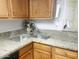 Updated kitchen with stone countertops, stainless steel faucet, and wood cabinets at 16402 N 31St St # 134, Phoenix, AZ 85032