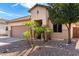 Charming front yard featuring desert landscaping, including palm trees, enhancing the curb appeal of this residence at 17063 W Nottingham Way, Surprise, AZ 85374