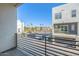 Balcony view with black metal railing, overlooking a modern cityscape with blue skies and palm trees at 1717 E Morten Ave # 16, Phoenix, AZ 85020