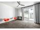 A bright bedroom featuring a ceiling fan and glass door to the patio at 1717 E Morten Ave # 16, Phoenix, AZ 85020