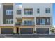Contemporary townhome featuring stone accents, dark garage doors, and a private balcony with iron railings at 1717 E Morten Ave # 16, Phoenix, AZ 85020